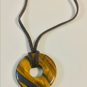Beautiful tigers eye donut pendant with brown suede necklace with hook closure.